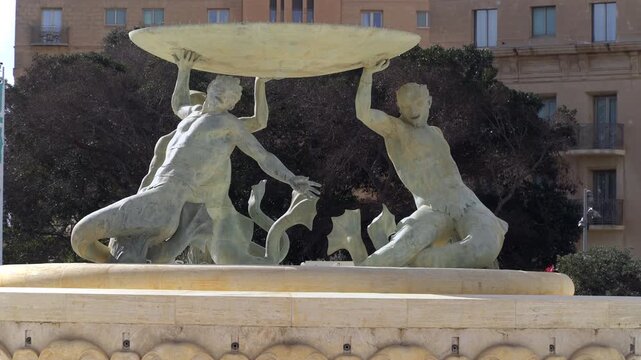 Close-up of the bronze triton figures supporting the Tritons' Fountain in Floriana, Malta, one of the island's most important modernist landmarks.
