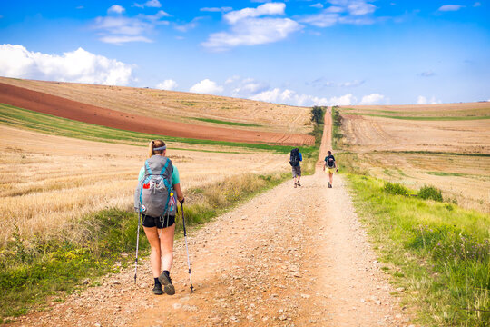 Solo Gen Z woman with a backpack hiking the Camino de Santiago French Way in Rioja. Young female traveler experiencing freedom and safe exploration on the historic pilgrimage route in Spain.