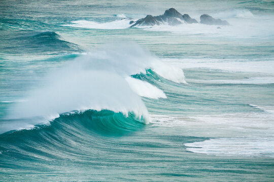 Spray blowing off the crests of huge waves breaking in the ocean