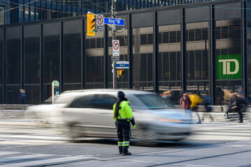 Naklejka premium Traffic officer downtown Toronto, by a TD bank skyscraper, Canada