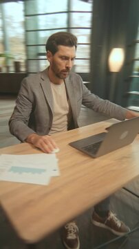 Person carefully assesses digital simulations while surrounded by indoor plants and organization units