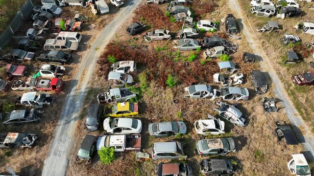 Aerial drone capture of a large junkyard with scattered vehicles and scrap metal piles, highlighting the lifecycle of end-of-life vehicles and industrial recycling operations.
