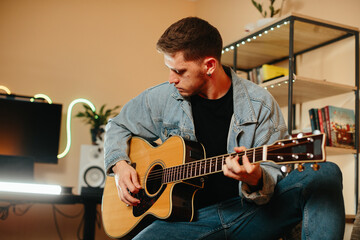 Obraz premium Musician composing music playing acoustic guitar at home studio