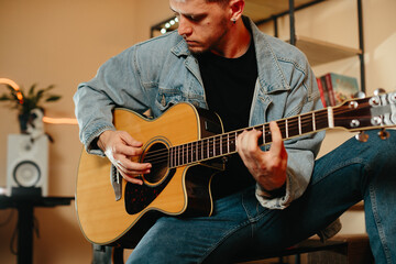 Obraz premium Musician composing music at home playing acoustic guitar