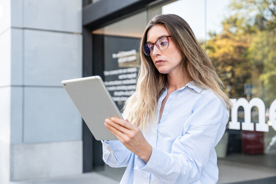 Confident businesswoman using tablet outdoors