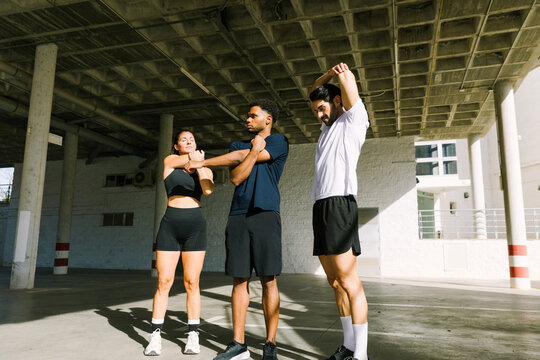 Multiethnic friends stretching together before jogging