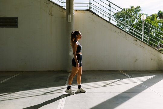 Woman in athletic wear in urban sunlight