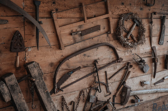 Rustic vintage tools displayed on wooden wall surface