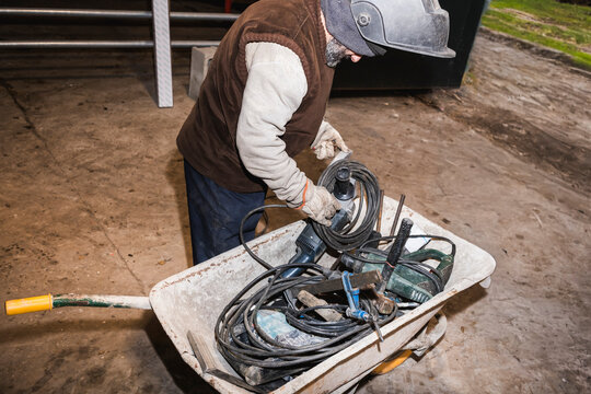 Worker organizing tools in a wheelbarrow