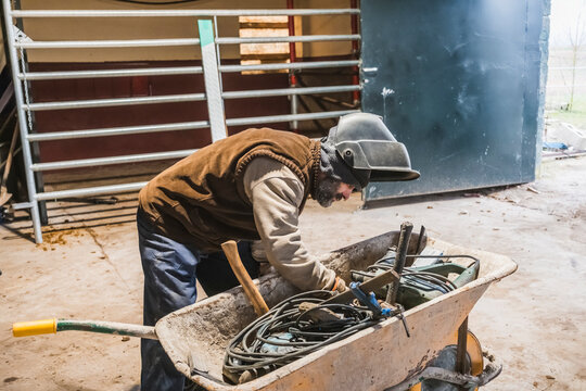 Worker organizing tools in a wheelbarrow