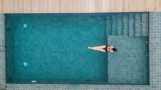 Woman relaxing in a swimming pool during summer