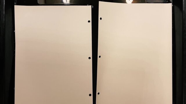 Natural paper dyeing process for junk journals and scrapbooking. Two sheets of textured paper are being dipped into a liquid with natural coloring matter, acquiring deep amber and warm sepia tones.