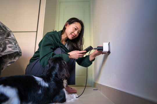 Woman using smart plug for energy-efficient home device