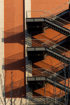 Industrial fire escape on a brick building with shadows