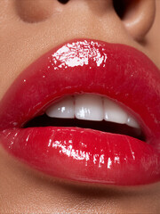 Obraz premium Close up view of shiny red lips with white teeth showing in bright light