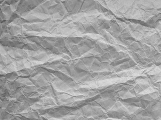 Fototapeta premium Crumpled paper shows gentle creases and soft shadows. Texture feels tactile, natural, and slightly worn. Gray tone gives quiet, neutral mood to the surface. Ideal background for design, art