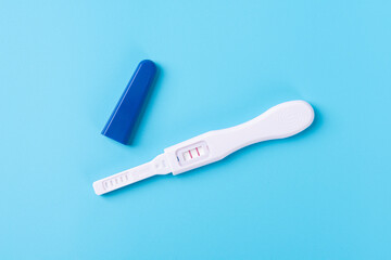 Obraz premium Pregnancy test showing positive result on blue background