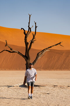 Lone traveler in desolate Deadvlei, Namibia desert landscape