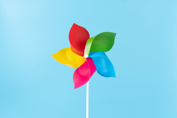 Colorful pinwheel spinning on blue background symbolizing childhood joy