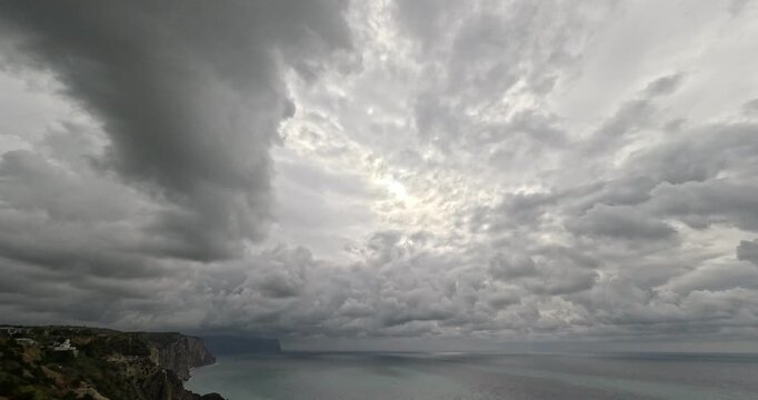 Clouds storm timelapse dramatic grey sky moves quickly over a rugged ocean cliff edge