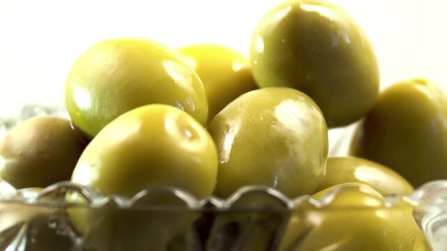 Macro of green Olives (Olea europaea) in crystal bowl rotating 180
