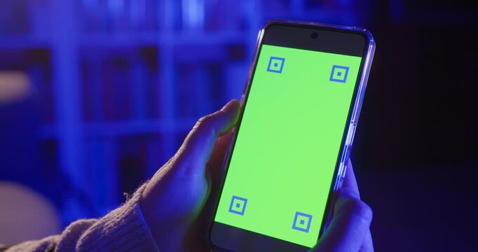 Woman holding a smartphone at home in the night