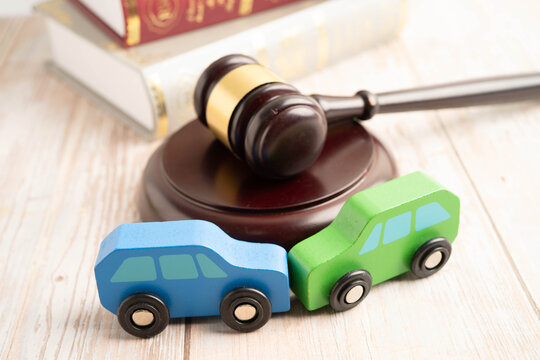 Car accident lawsuit and insurance, Judge hammer with car model.