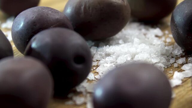 Dark Olives (Olea europaea) with coarse sea salt, moisture extraction during dry curing, Illustration of aggressive osmosis