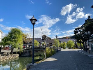 Obraz premium Kurashiki Bikan Historical Quarter with traditional white-walled buildings and willow trees along the canal, Okayama, Japan 