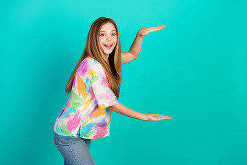 Cheerful young woman in casual colorful outfit gesturing and smiling against a vibrant turquoise background