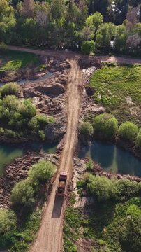 Dumper cruzando camino de un solo carril preparado para cantera de aridos. Impactos medio ambiental en suelo rural