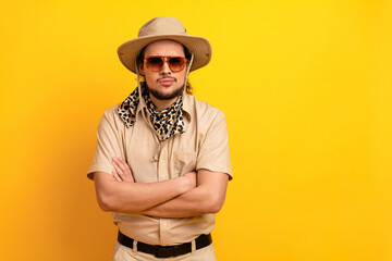 Man in safari outfit stands against bright yellow background adventure travel style and summer vacation vibes for a bold adventurous traveler © deagreez
