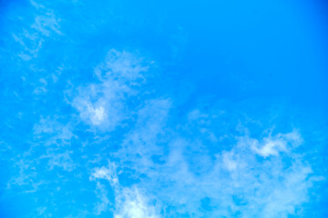 Obraz premium Blue sky background with diffuse white clouds and ample copy space.