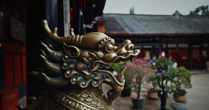 Chengdu, Sichuan, China. Bronze Lion head sculpture. Statue of mystical Chinese guardian lion. Head of golden Lion statue at Wenshu monastery. Brass lion guards entrance to temple. Sculptures Of