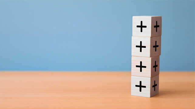 A stack of five white wooden blocks, each with a black plus sign, symbolizing positive growth, accumulating benefits, and continuous progress against a clean blue background