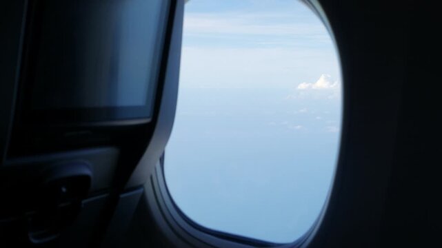 view inside airplane aircraft through plane window with aircraft seat in cabin while flying over sky in summer flying climbing take off to sky. airplane traveling holiday vacation background