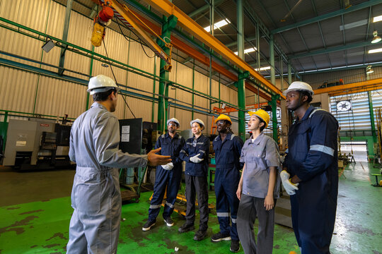 Team meeting on industrial safety procedures manufacturing plant group discussion indoor perspective workplace culture
