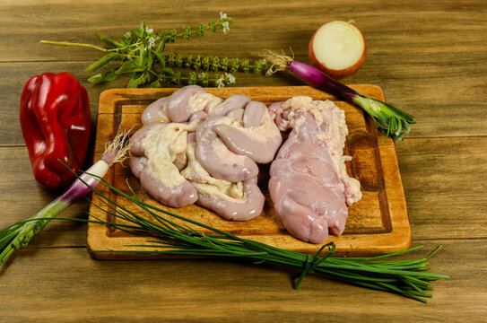 Cow bowels presented on a wooden board with ingredients, ready to grill