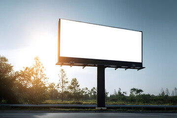 Obraz premium Empty billboard beside a highway with trees and sunlight in the background during early morning hours