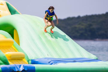 Obraz premium Girl playing on inflatable floating water park