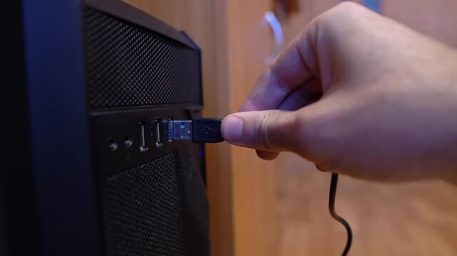 Connect a black USB cable to a computer's USB port in the office
