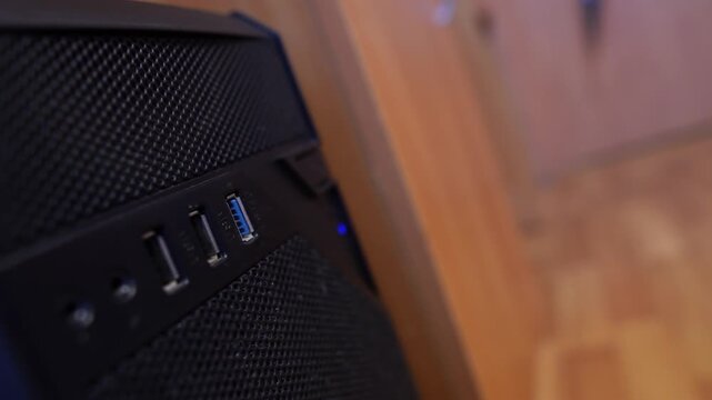 Connecting a blue flash drive to a computers USB port in the office, close-up view, technology