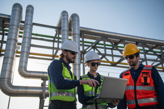 Industrial Engineers Inspecting Construction Site with Laptop, engineering teamwork, industrial inspection, project management and modern construction technology.