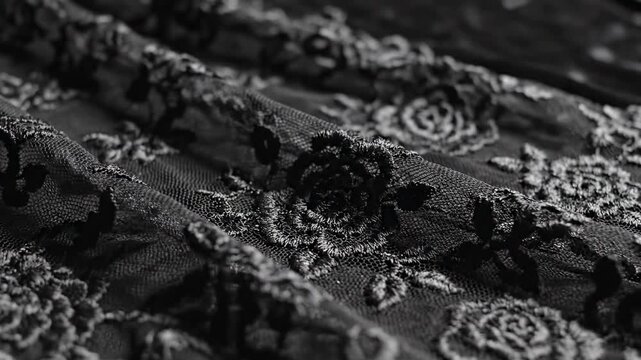 Macro close-up of luxurious black wedding dress fabric with intricate floral embroidery and lace details