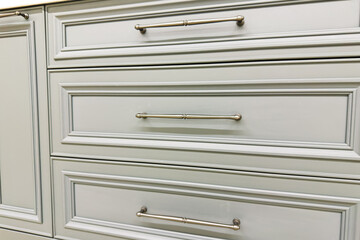 Clean light gray kitchen cabinet drawers with brushed metal pulls