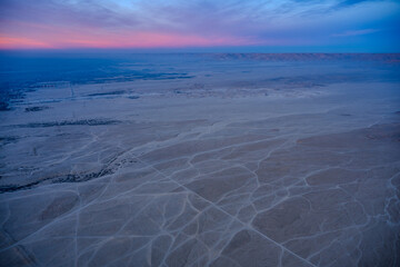 Aerial view of desert tracks at dusk with distant mountains