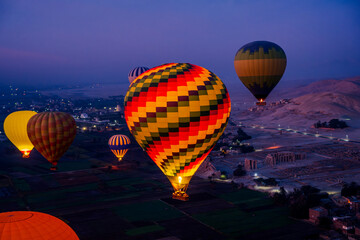Colorful hot air balloons flying over the temples of Luxor at dawn © Emad Aljumah
