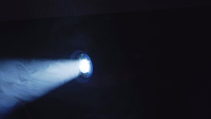 Naklejka premium Light beam projecting through smoke, creating a blue hazy atmosphere