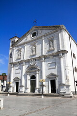 Fototapeta premium Grand white church exterior against blue sky, Palmanova, Italy