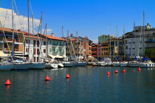 Sailboats moored in a vibrant waterfront town, Grado, Italy